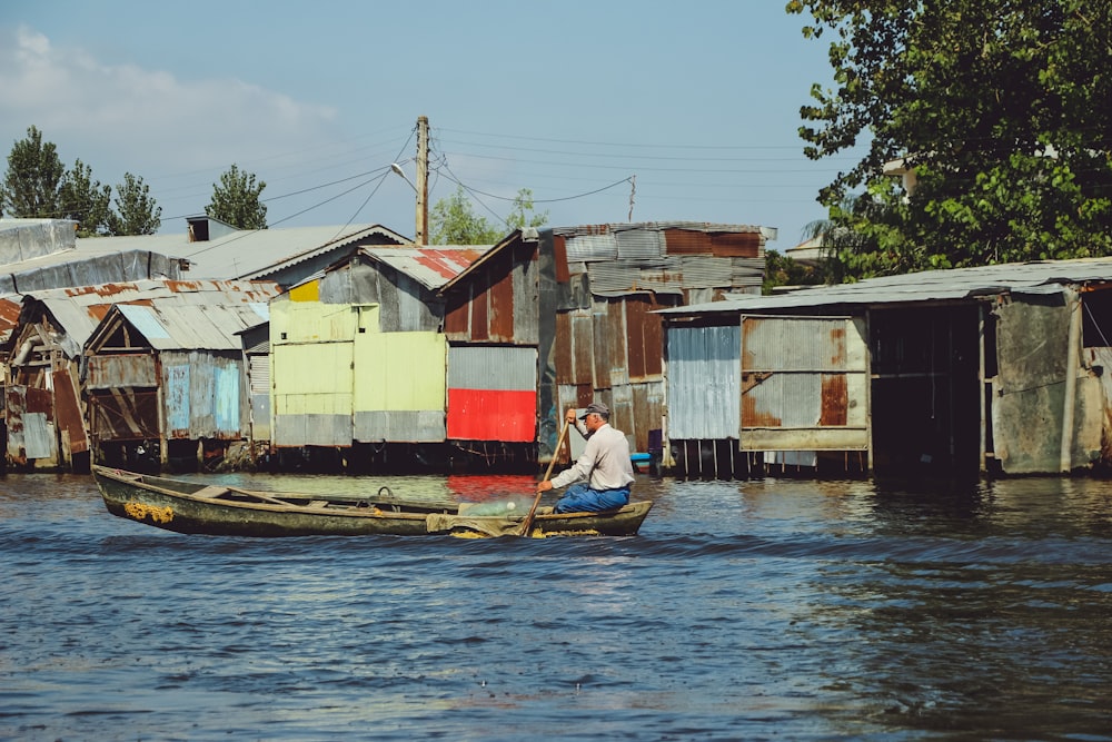 man in white shirt riding on boat on river during daytime