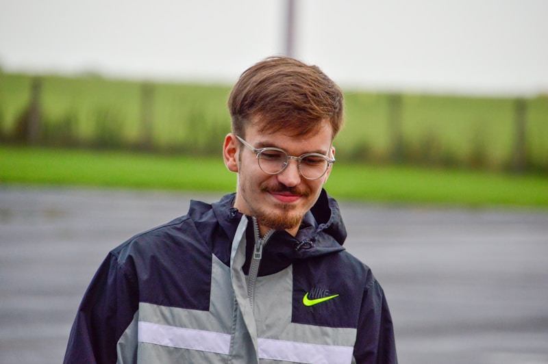 man in black and gray jacket wearing eyeglasses