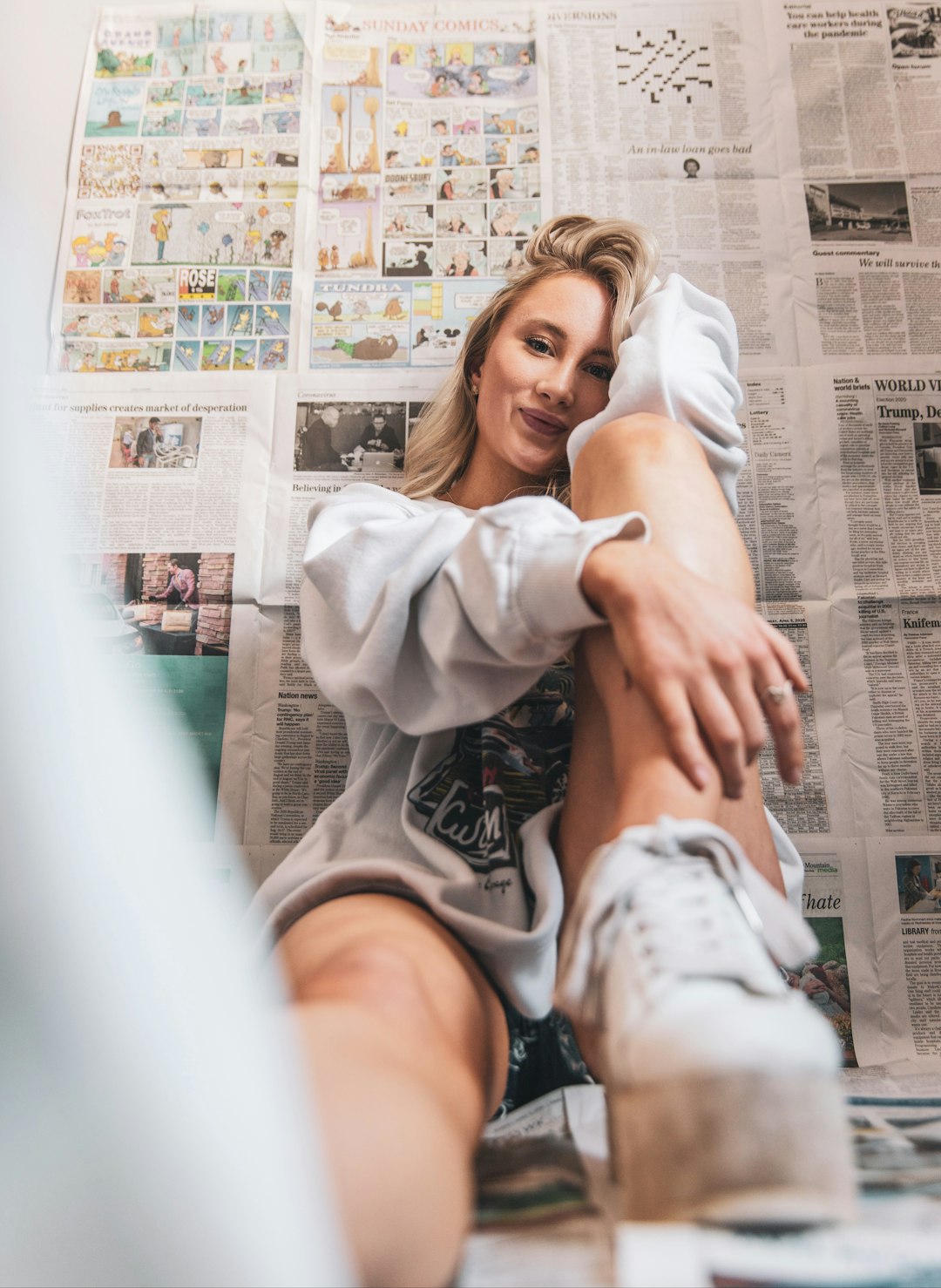 woman in white long sleeve shirt and black shorts sitting on white chair