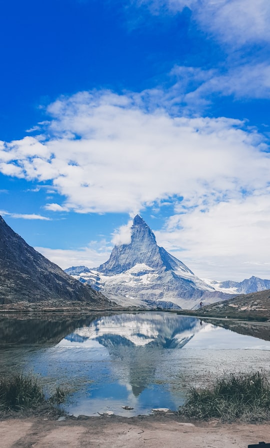 snow covered mountain under blue sky and white clouds during daytime in Matterhorn Switzerland