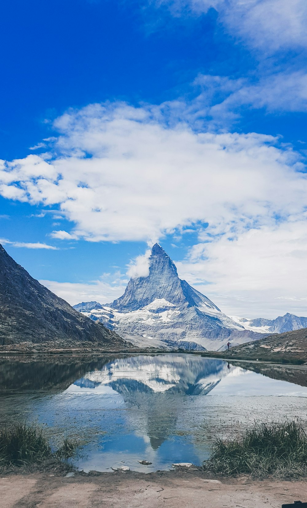 snow covered mountain under blue sky and white clouds during daytime