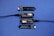 A series of electronic components displayed on a blue surface, including two black modules labeled 'Plant Wing' with colorful bar graphics and USB connectors. Two black capacitive soil moisture sensors version 1.2 are also present, with one shown connected via black cables.