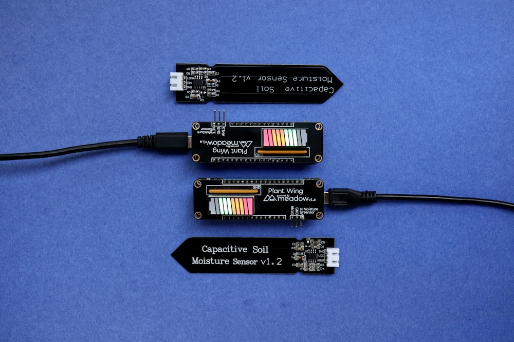 Tres componentes electrónicos colocados encima de una superficie azul