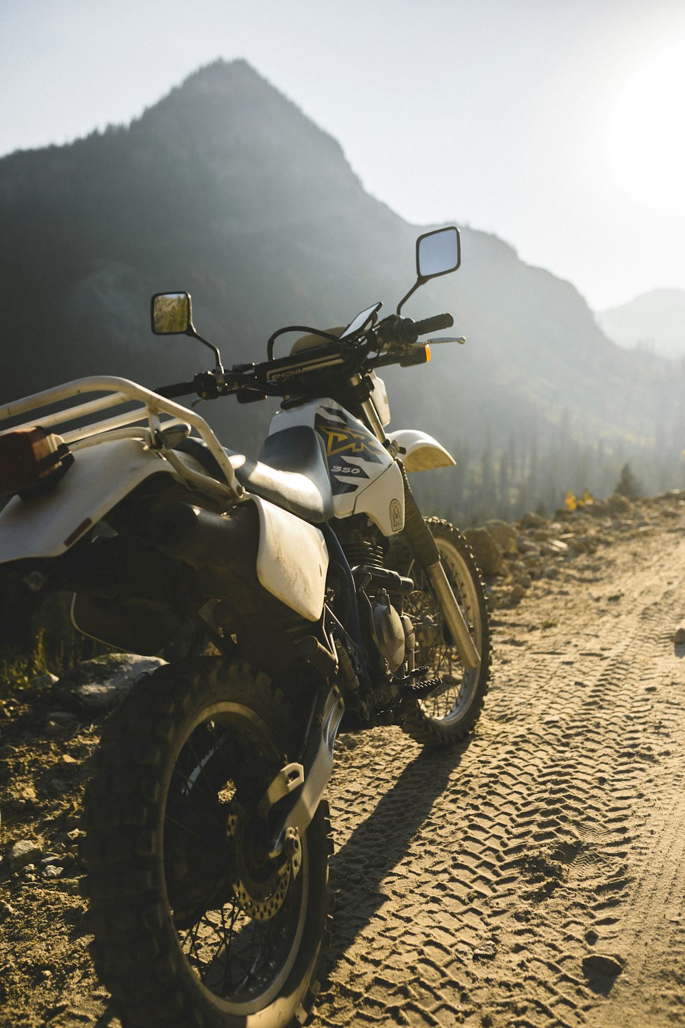 white and black motorcycle on brown sand during daytime