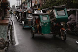 Electric tricycles branded with KMI navigating a bustling Monrovia street.