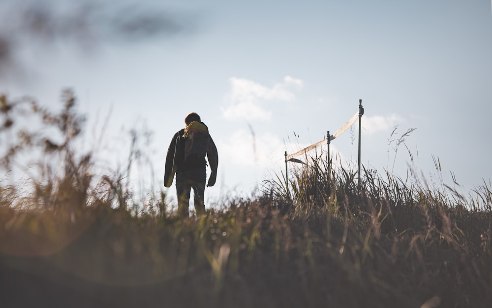 man in black jacket standing on green grass field during daytime