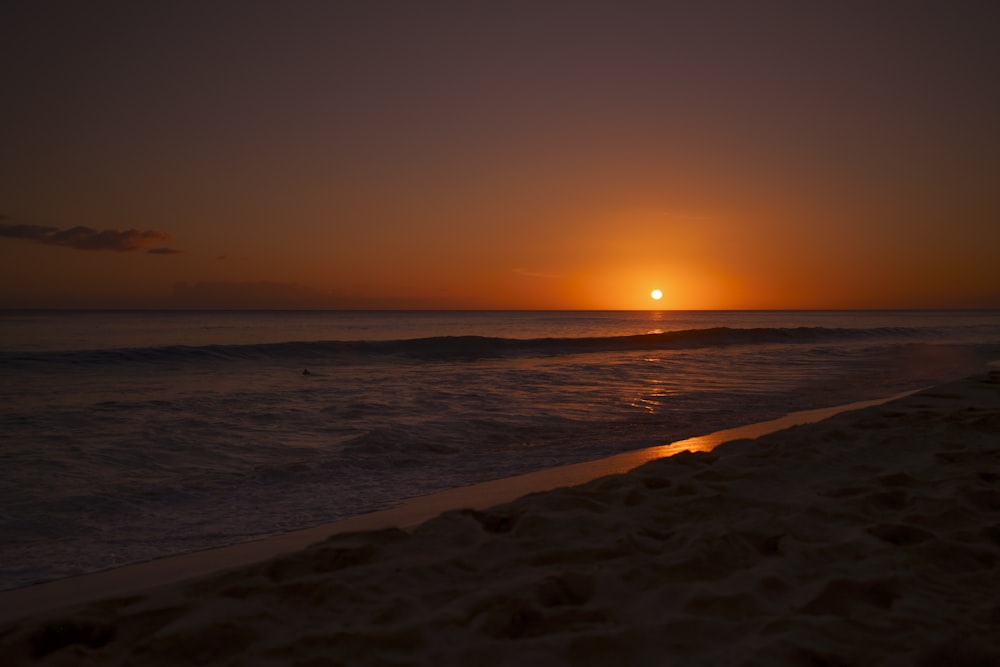 sea waves crashing on shore during sunset