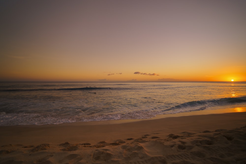 ocean waves crashing on shore during sunset