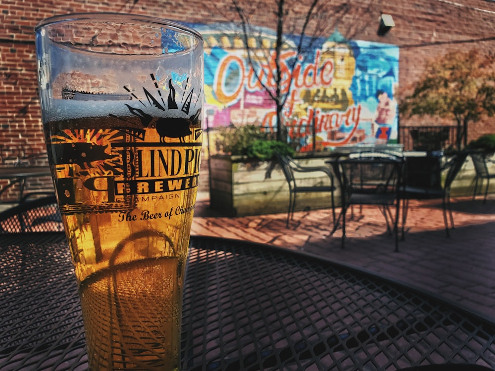 clear drinking glass with beer on black metal table