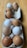 A dozen eggs in various shades of brown and white are placed in two cardboard egg cartons on a wooden surface. Some eggs have slight textures or marks on their shells.