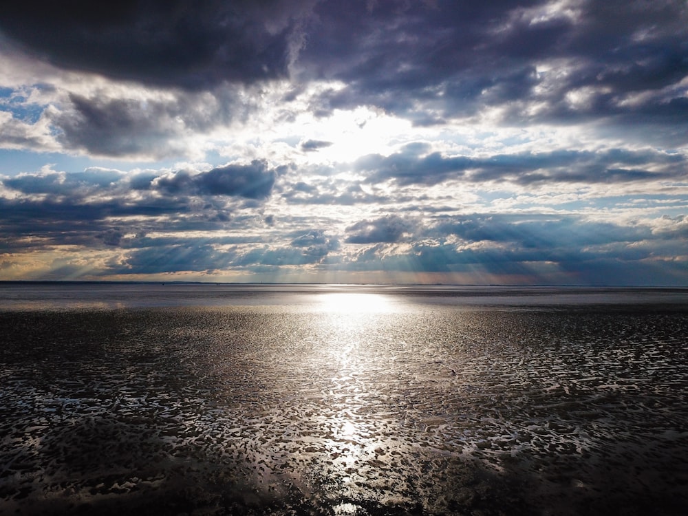 specchio d'acqua sotto il cielo nuvoloso durante il giorno