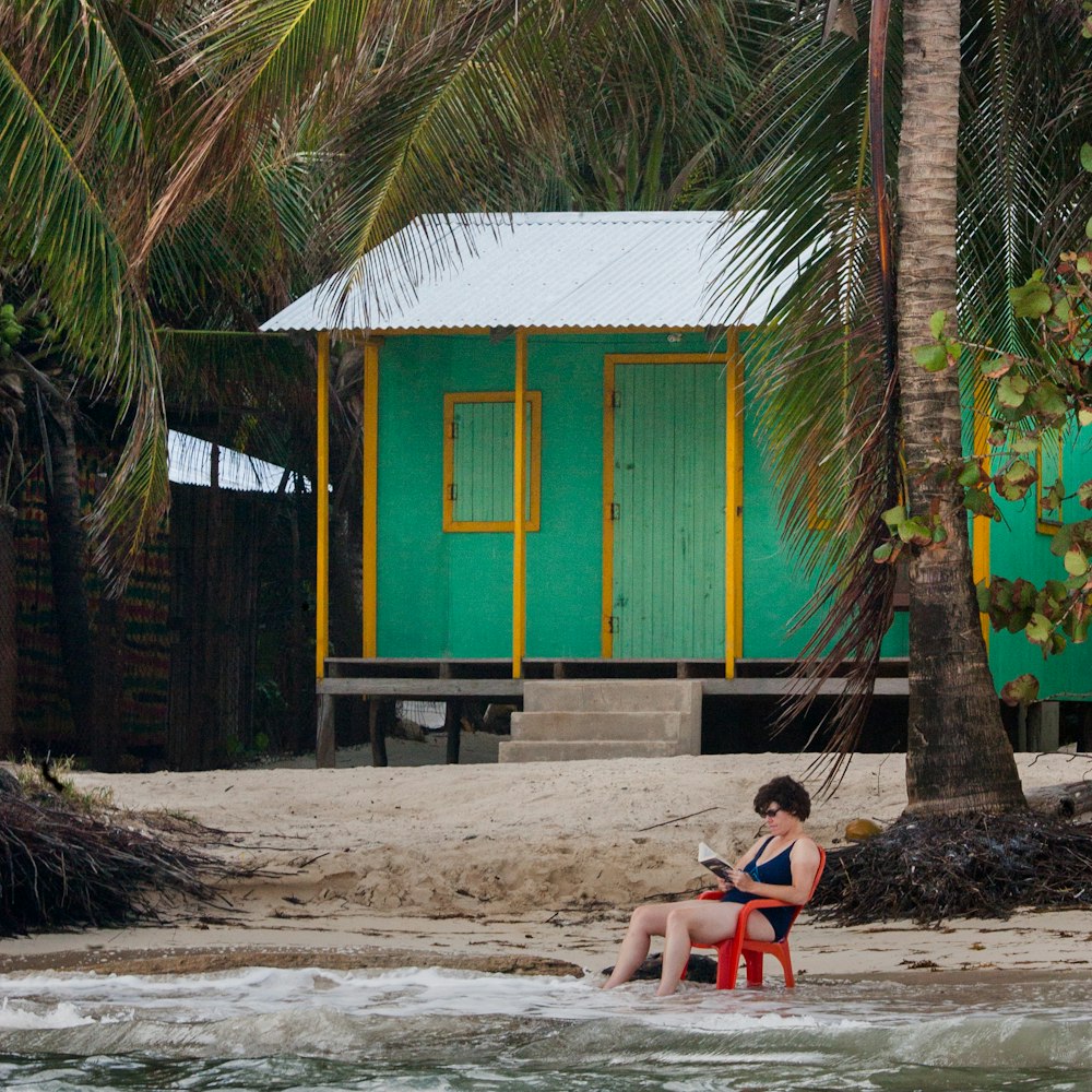 2 women sitting on beach shore during daytime