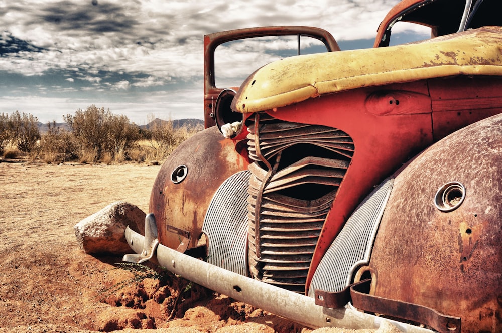 red vintage car on brown soil during daytime