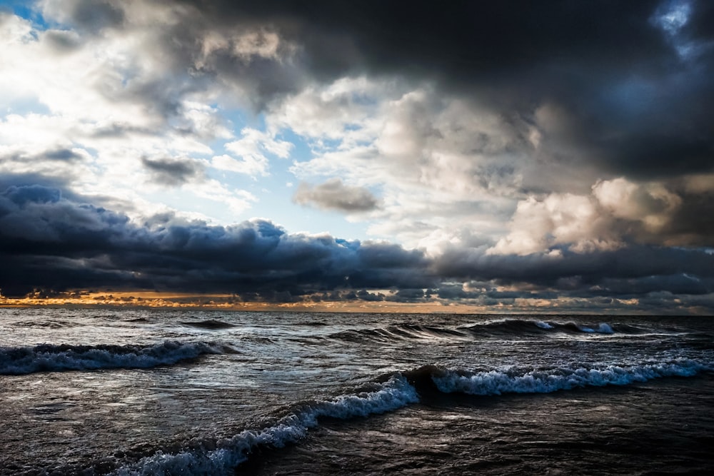 ocean waves under cloudy sky during daytime