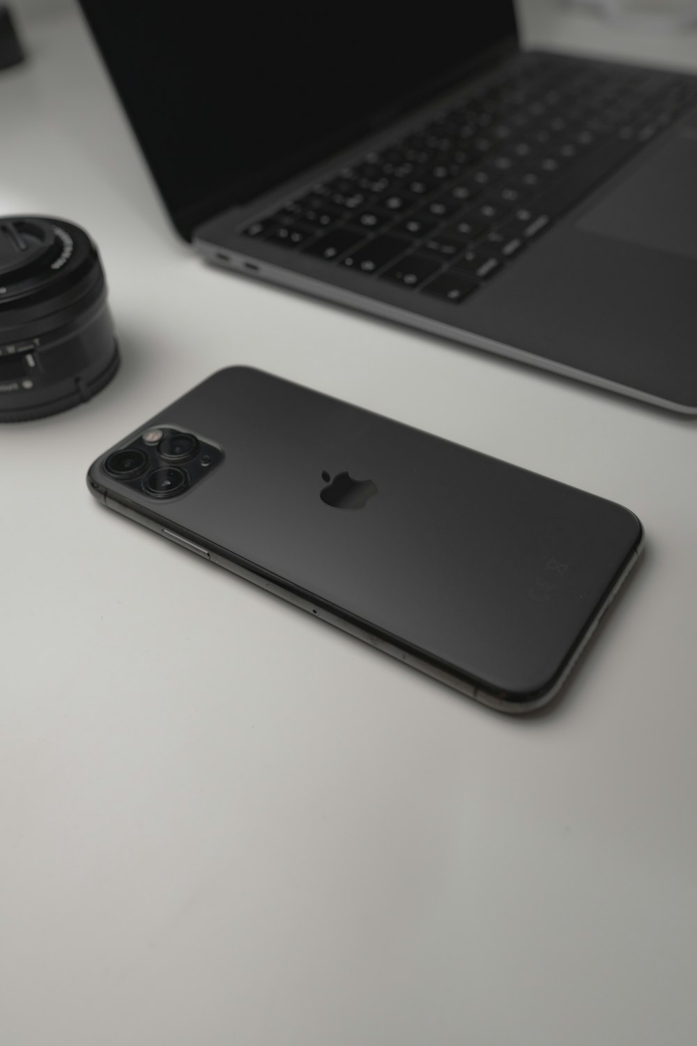 iPhone 7 nero accanto all'obiettivo nero della fotocamera e all'obiettivo nero della fotocamera