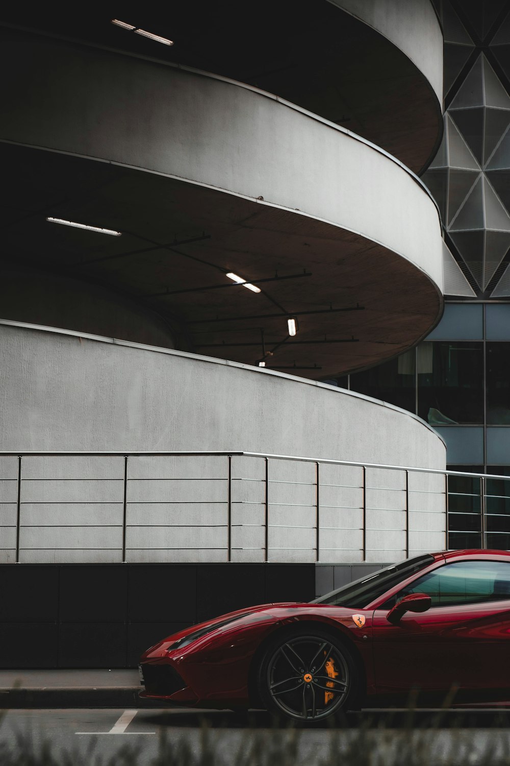 red car parked near white concrete building