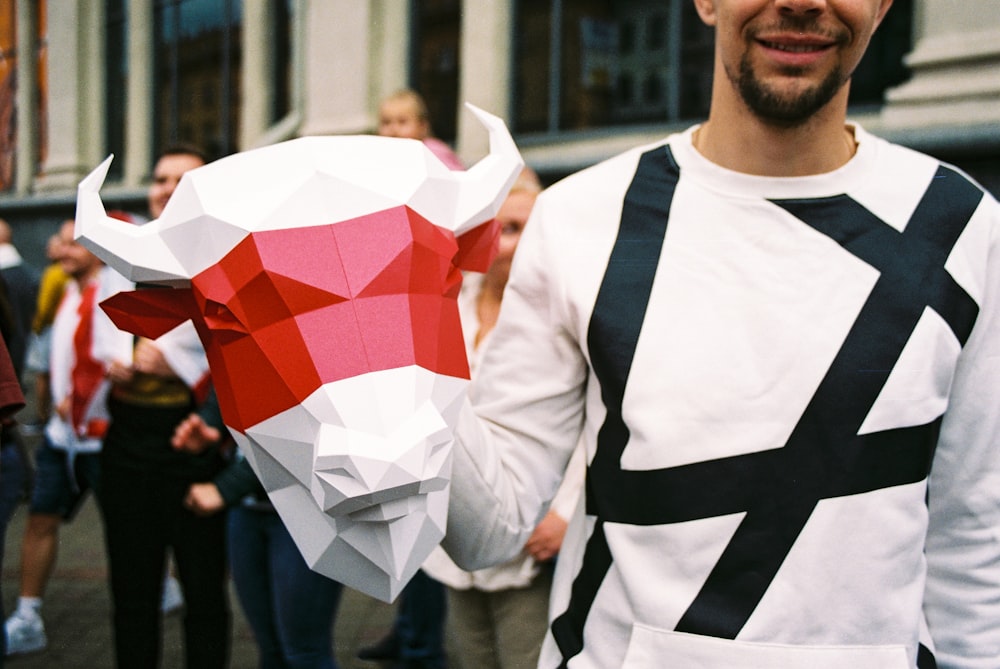 man in white and black long sleeve shirt holding red and white umbrella