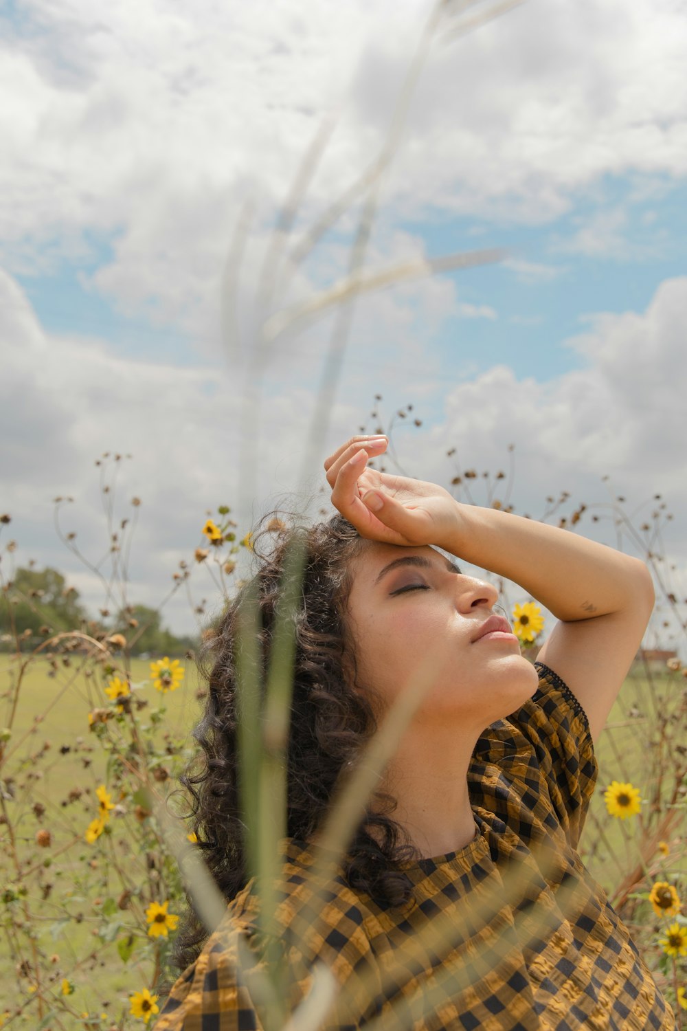 woman in yellow and black tank top holding her hair