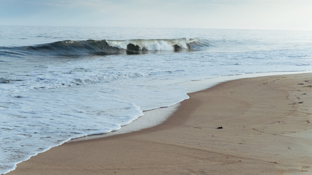 ocean waves crashing on shore during daytime