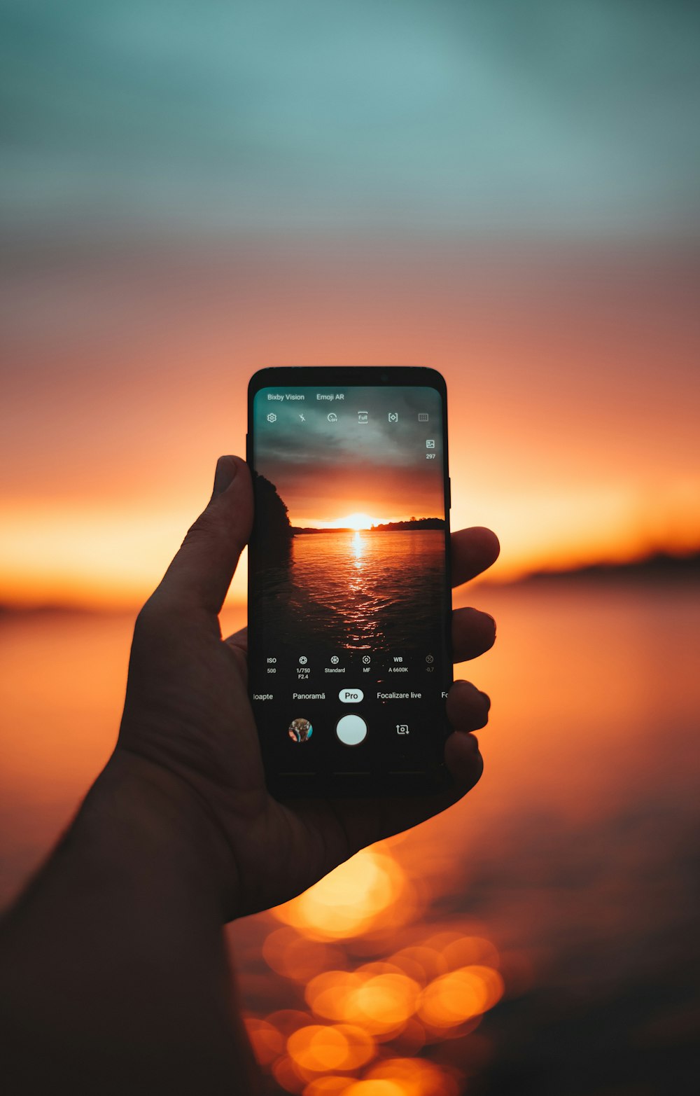 person holding black smartphone taking photo of sunset