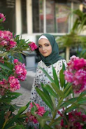 Bright spring outfit with a floral skirt, light blouse, and pastel hijab.
