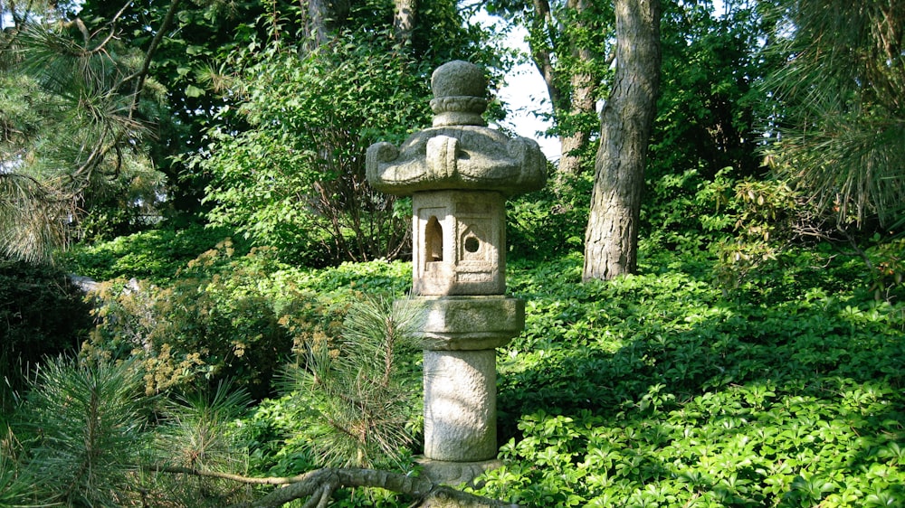 gray concrete outdoor fountain surrounded by green plants during daytime