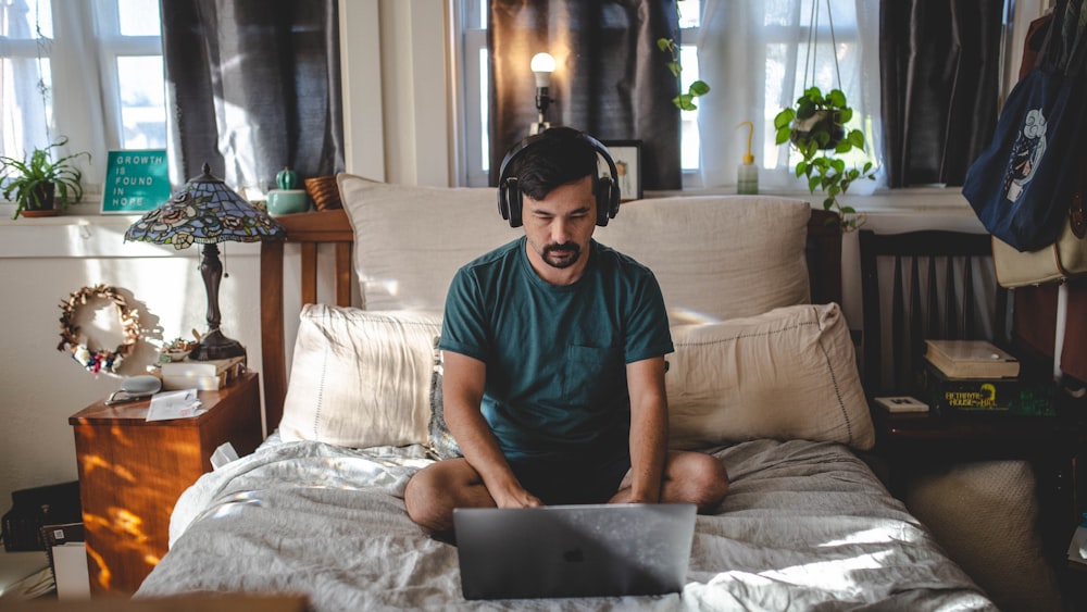 man in green crew neck t-shirt sitting on white sofa