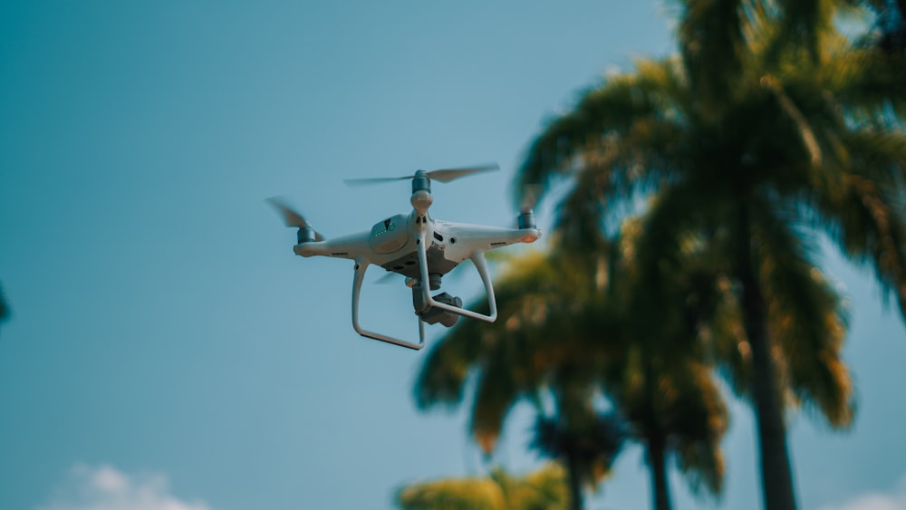 white drone flying in the sky during daytime