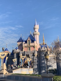 Children playing near a whimsical castle entrance with colorful flags fluttering.
