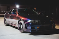 Night photo of a sports car with reflections emphasizing the depth and gloss of the paint protection.