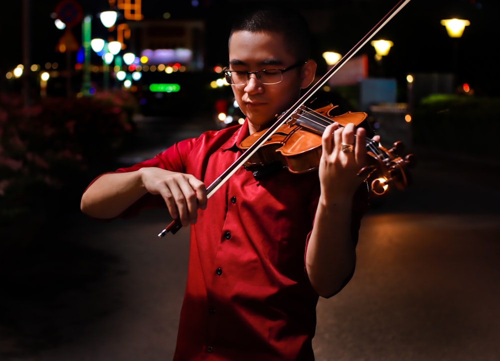 man in red dress playing violin