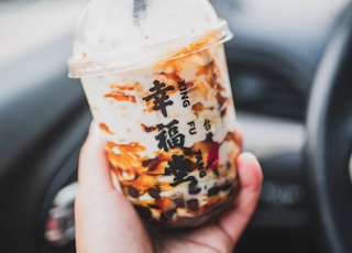 person holding ice cream in disposable cup