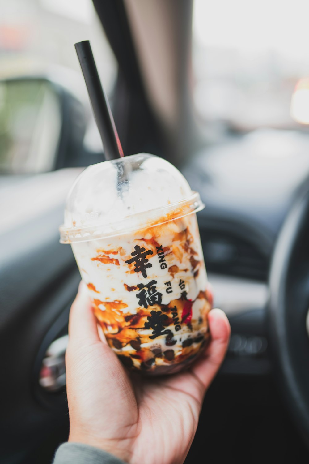 person holding ice cream in disposable cup