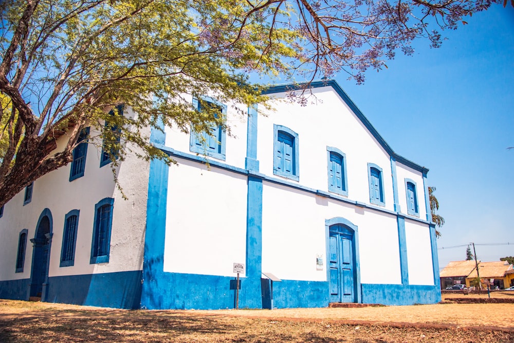 white and blue concrete building near brown tree during daytime