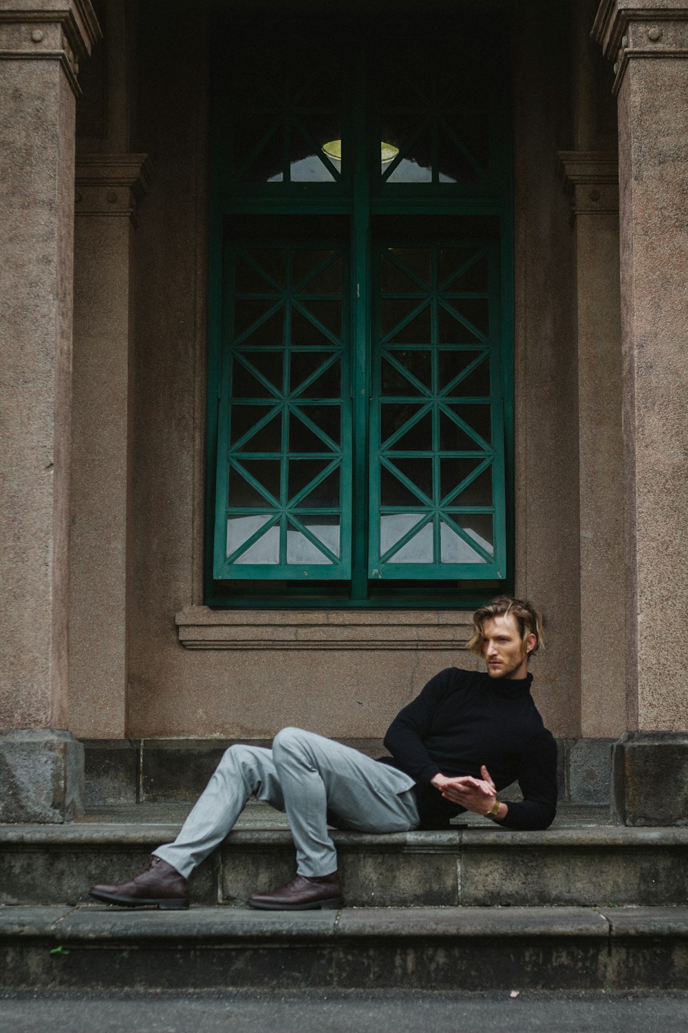 woman in black long sleeve shirt and gray pants sitting on gray concrete bench