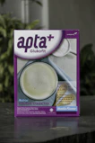 A box featuring a health-related product labeled 'apta+ Glukofit' with a purple and white design. The product claims a vanilla flavor and highlights benefits for diabetes, including low sodium and lactose content, high fiber, vitamins, and calcium. The front design includes a photo of a white beverage to suggest consumption.