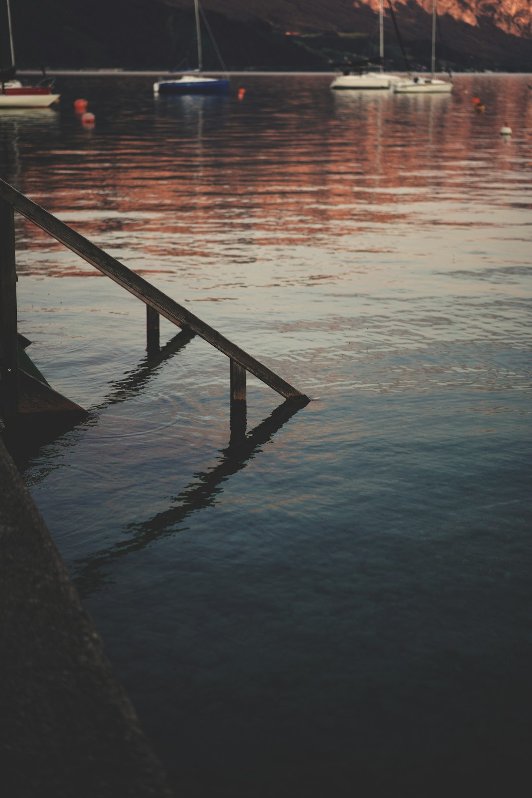 brown wooden dock on body of water during sunset