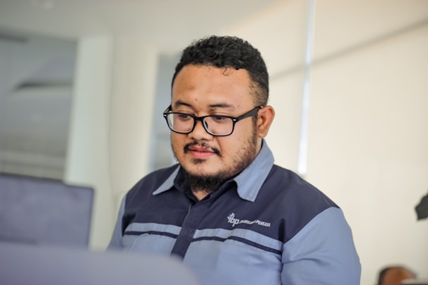 A professional cleaner in uniform carefully cleaning a modern office space.