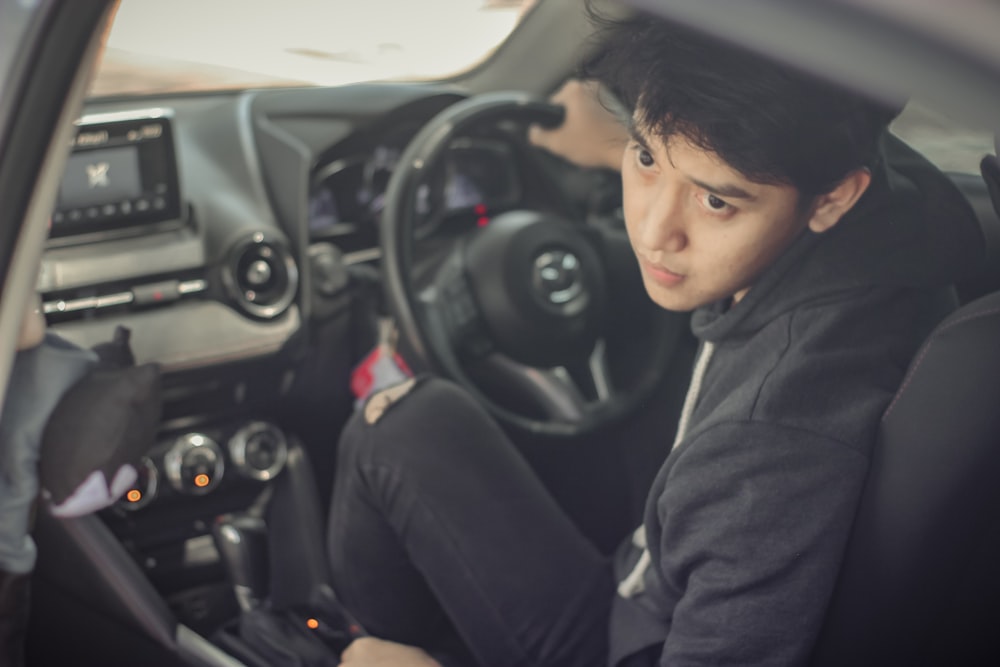 woman in black hoodie sitting on drivers seat