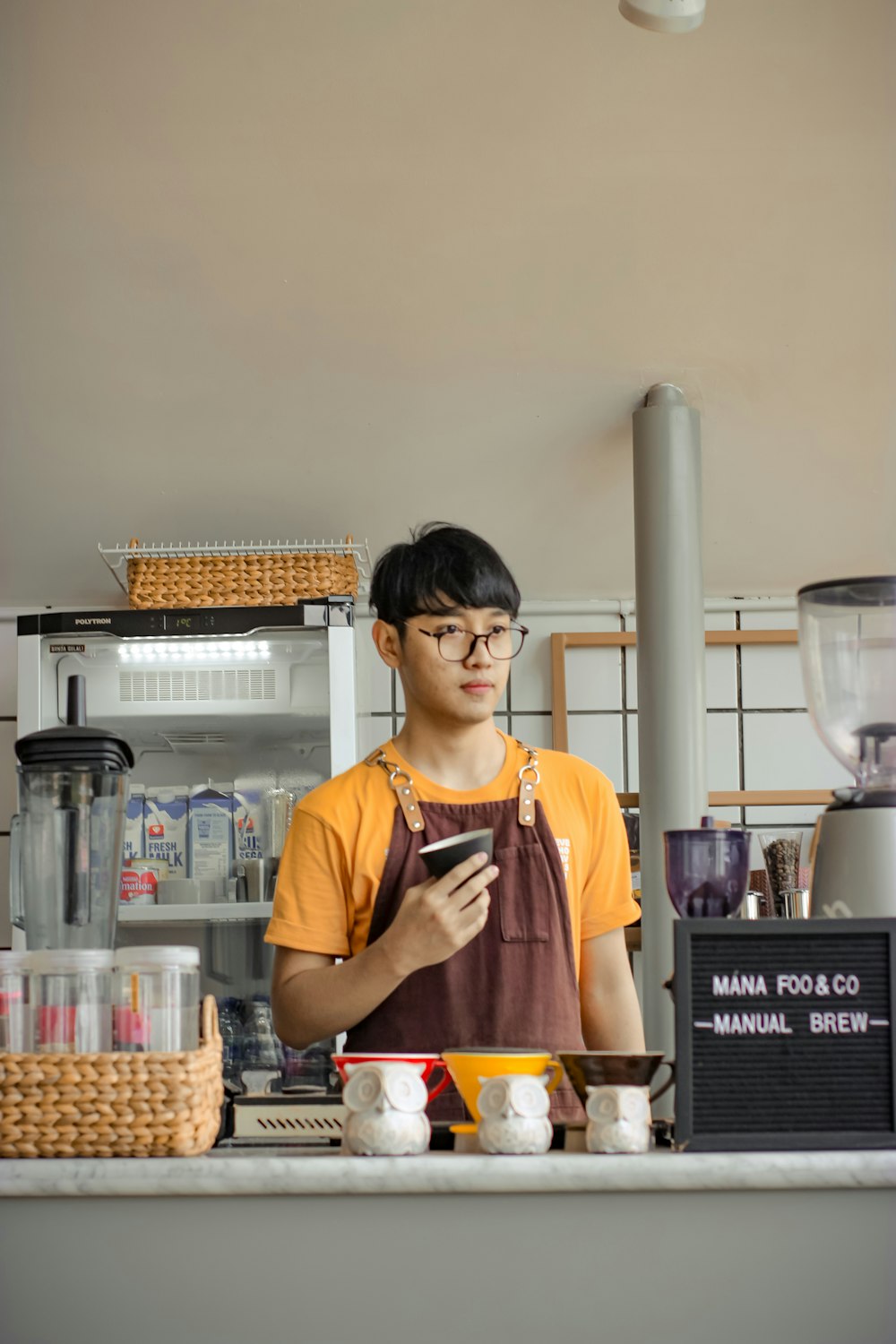 woman in orange apron holding orange and yellow labeled box