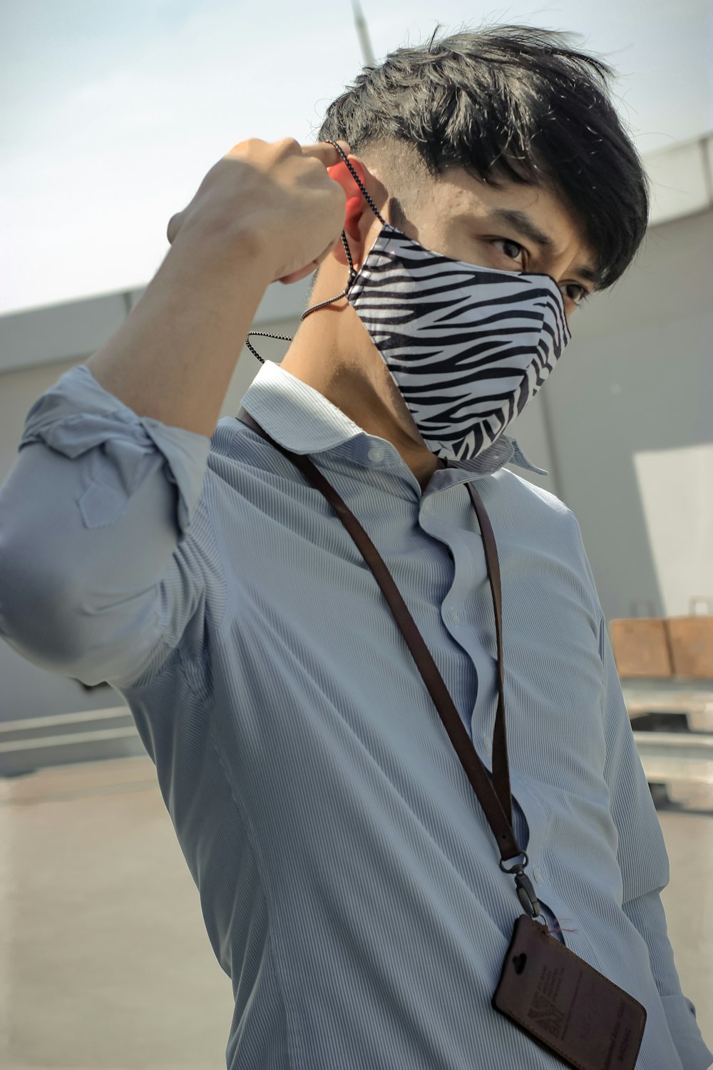 man in blue dress shirt wearing black and white striped necktie