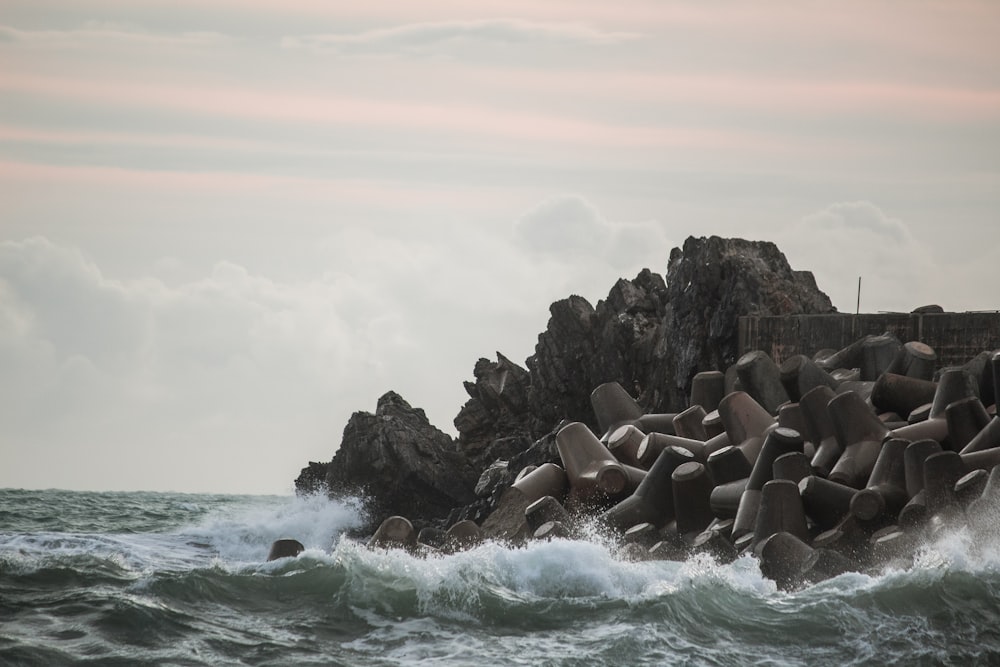 gray rocks on sea under white sky during daytime