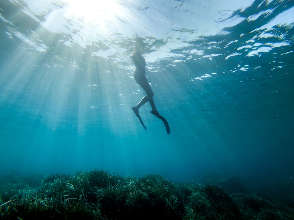 woman in black long sleeve shirt and black pants under water