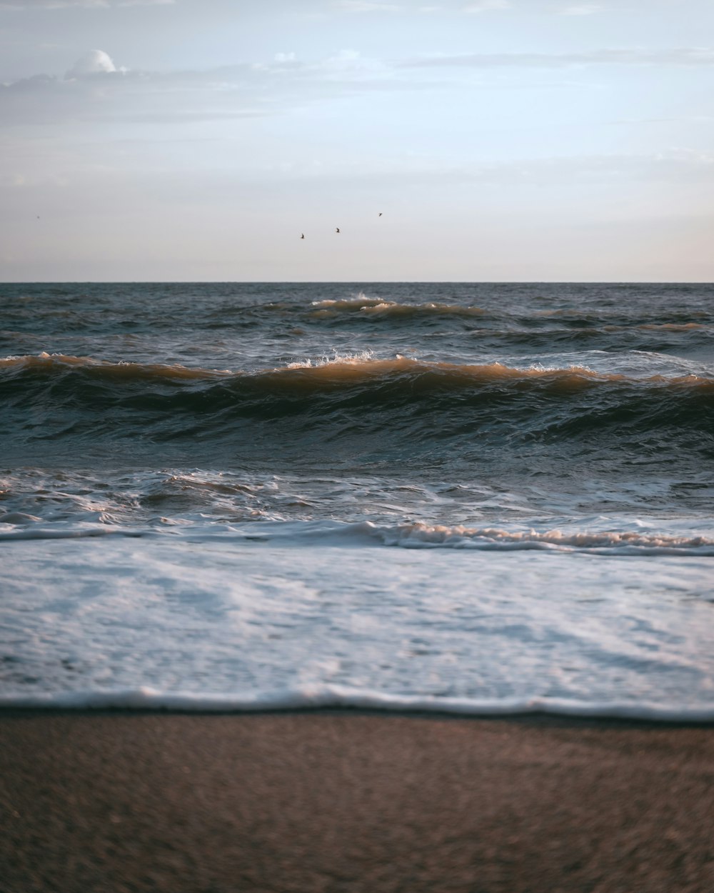 ondas do oceano batendo em terra durante o dia