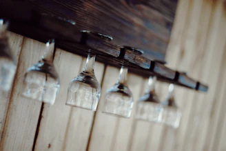 A sleek modern wine cabinet with a wall-mounted wine rack and hanging glass rack in a cozy home setting.