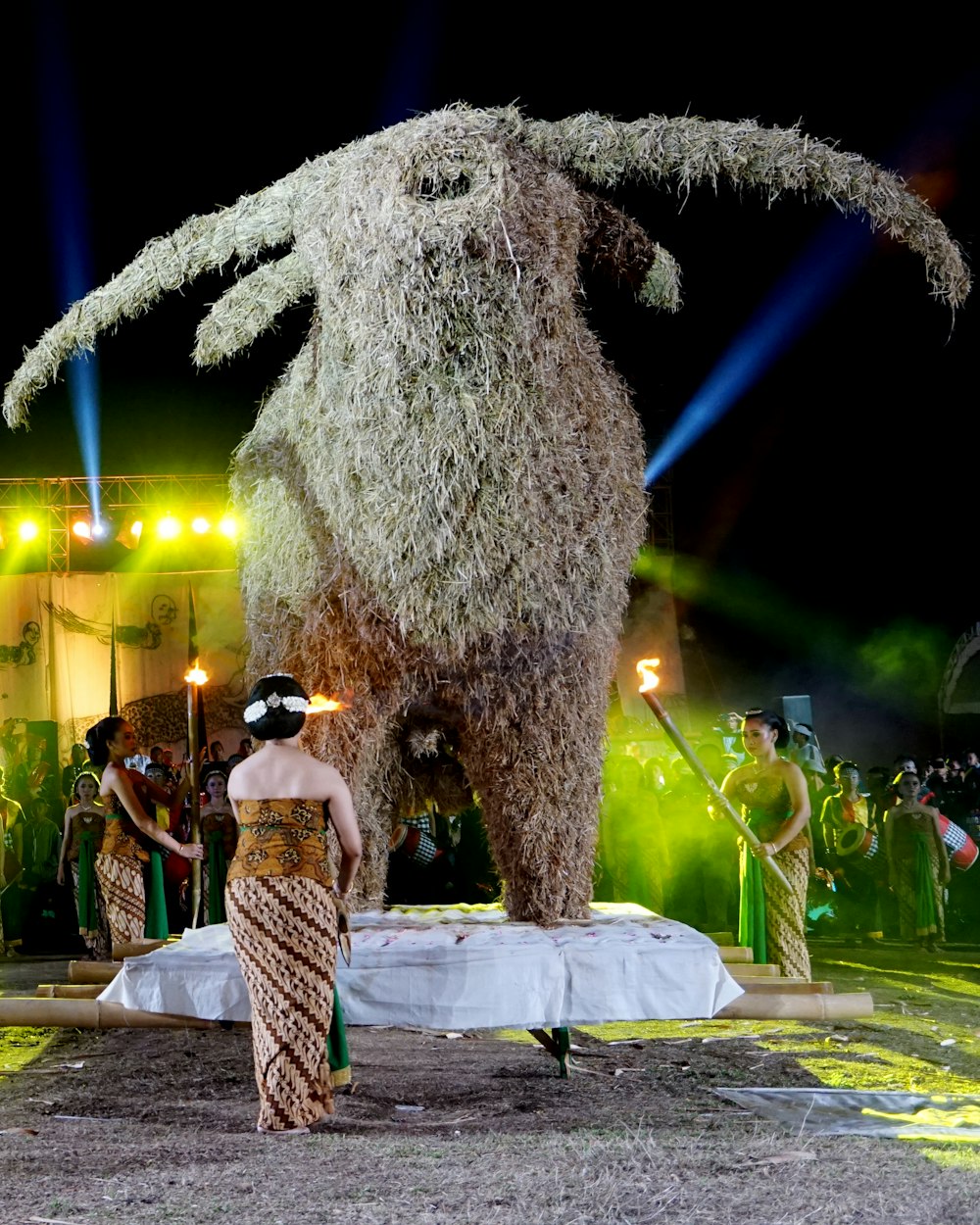 woman in black and white dress standing beside gray bear statue during night time