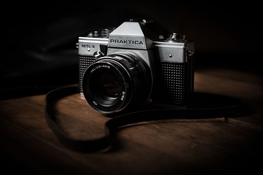 black and silver pentax camera on brown wooden table