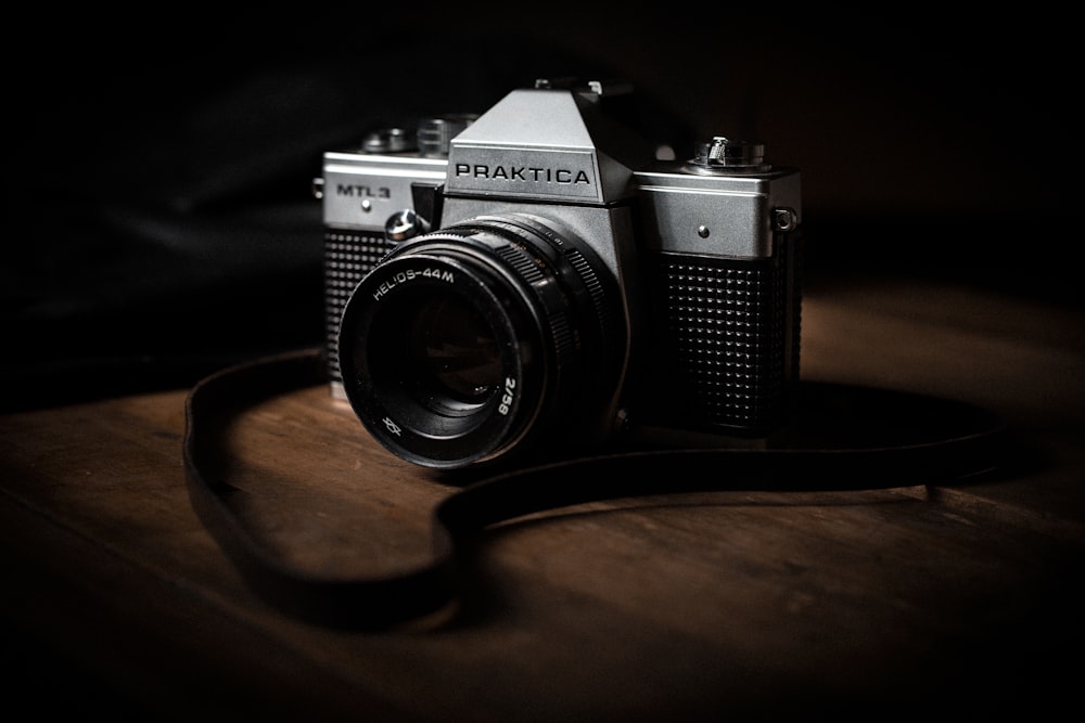 schwarz-silberne Pentax-Kamera auf braunem Holztisch