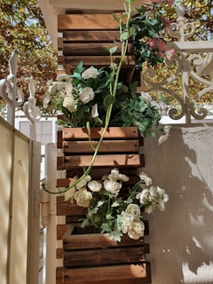 Wooden planter boxes arranged on a sunny terrace with blooming flowers