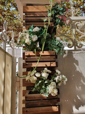 Vertical planters filled with vibrant flowers hanging on a wooden fence in a cozy garden.